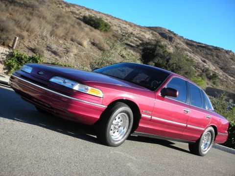 1992 Ford Crown Victoria - This 1992 Ford Crown Victoria is shown from a 3/4 front angle against a backdrop of a dry, grassy hillside.