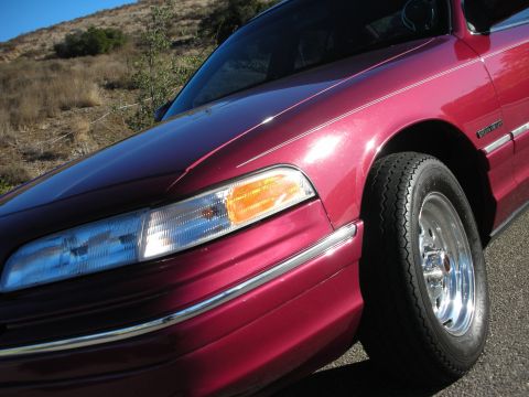 1992 Ford Crown Victoria - Close-up of a 1992 Ford Crown Victoria's front fender and headlight assembly.