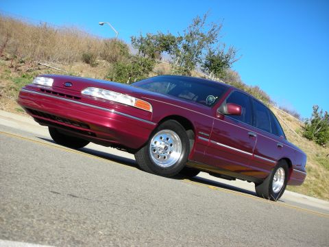 1992 Ford Crown Victoria - A maroon 1992 Ford Crown Victoria is shown from a low angle on a sunny day.