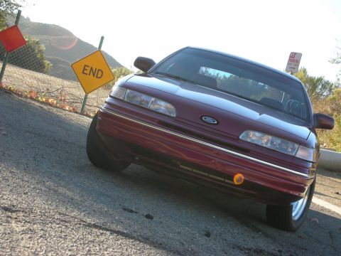 1992 Ford Crown Victoria - A maroon 1992 Ford Crown Victoria is parked near an 'END' road sign.