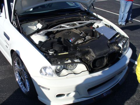 1991 Ford Probe - Front view of a white BMW M3, hood open, revealing the engine and M-sport badging.