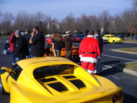 1991 Ford Probe - A gathering of cars and people, including someone dressed as Santa, in a parking lot on a sunny day.