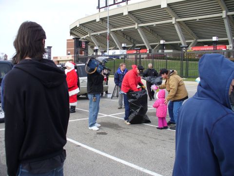 1991 Ford Probe - A group of people gather in a parking lot near a stadium, with one individual dressed as Santa Claus.