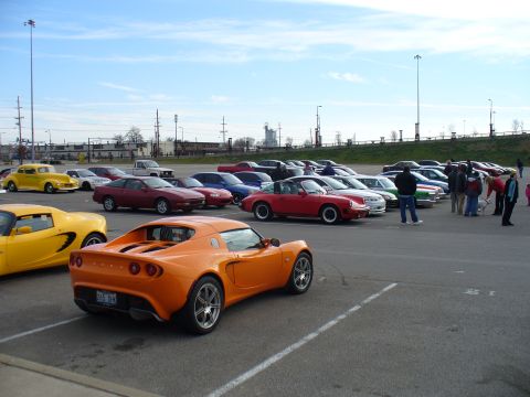 1991 Ford Probe - A gathering of cars in a parking lot, with an orange Lotus Elise prominently displayed.