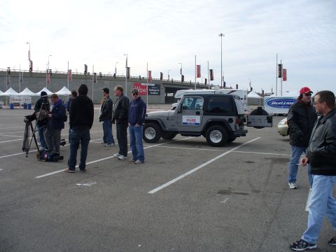 1991 Ford Probe - A film crew documents a Jeep Wrangler parked in an outdoor lot with tents and a Bud Light truck in the background.