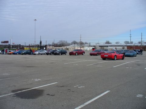 1991 Ford Probe - A red sports car is parked in a lot alongside several other vehicles under a cloudy sky.