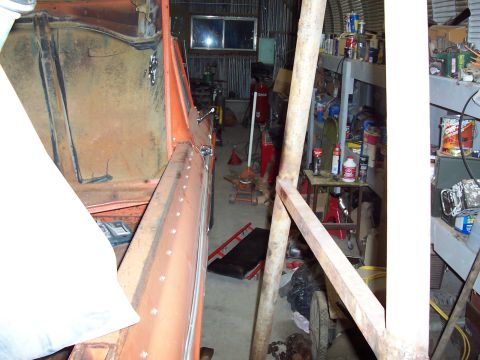 1972 Chevrolet C/K Pickup - The interior of an orange truck bed is shown, with a cluttered garage visible in the background.