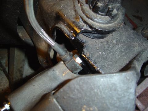 1986 Ford Bronco - This photo shows a close-up view of a brake line connection on a vehicle's suspension system.