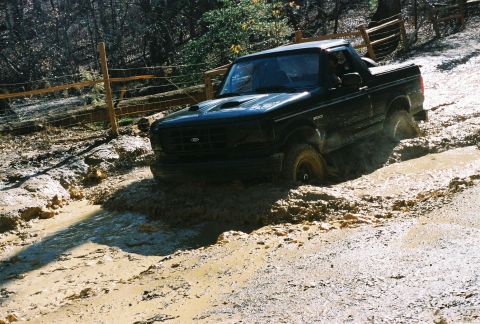 1978 Ford Bronco - This black Ford Bronco appears to be from the early 1990s, stuck deep in a muddy off-road trail.