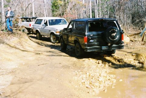 1978 Ford Bronco - Three Ford Broncos navigate a challenging muddy off-road course.