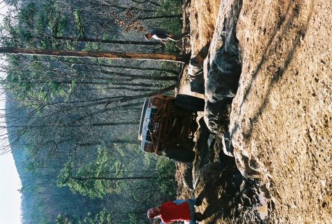 1978 Ford Bronco - A modified off-road vehicle attempts to ascend a challenging rocky terrain, with spectators observing the action.