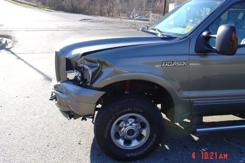 2002 Ford Excursion - 2002 Ford Excursion shows damage to the front passenger side after an accident.