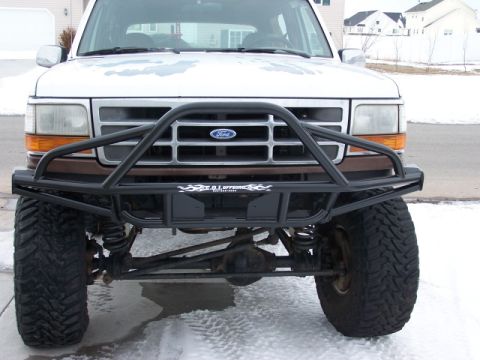 1995 Ford Bronco - This Ford Bronco features a custom front bumper and off-road tires, seen from a straight-on perspective.