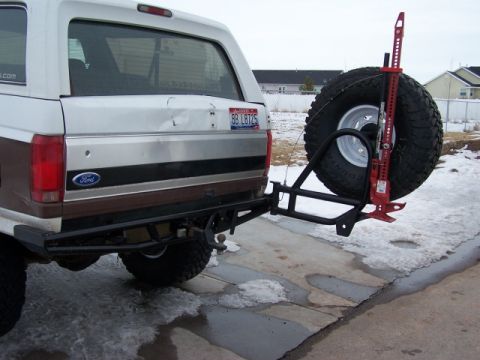 1995 Ford Bronco - Rear view of a 1995 Ford Bronco, equipped with a spare tire carrier and a Hi-Lift jack mounted on the tailgate.