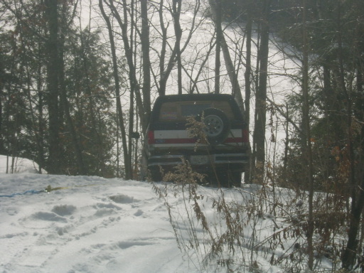 Rear view of a 1990 Ford Bronco in the snow with a spare tire on the back