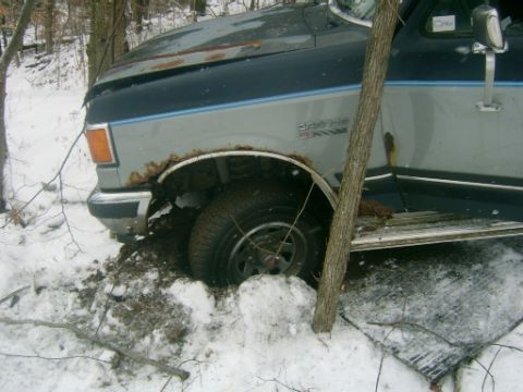 1990 Ford Bronco - This 1990 Ford Bronco is stuck in the snow with visible rust on the front fender.