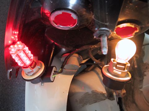 2003 Ford Crown Victoria - Close-up of a car's tail light assembly shows a red LED bulb and a yellow incandescent bulb.