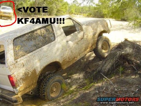1989 Ford Bronco - A white Ford Bronco is shown covered in mud while navigating a sandy, wooded terrain. Another vehicle is visible in the distance.