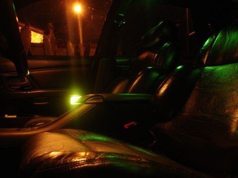 1993 Ford Taurus - The interior of a car is illuminated by green ambient lighting and an external street lamp.