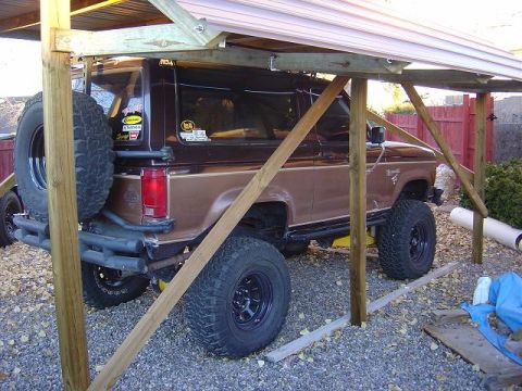 1986 Ford Bronco II - Brown 1986 Ford Bronco II with aftermarket bumper and spare tire, seen from the rear quarter angle.