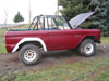 1968 Ford Bronco - A red 1968 Ford Bronco sits outside with its hood open, revealing the engine bay.