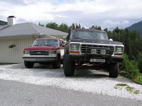 1978 Ford Bronco - Two Ford trucks, a 1978 F-Series and a Bronco, are parked on a gravel driveway near a house.