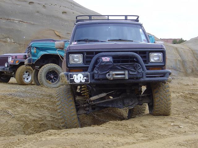Dark brown Ford Bronco II with a winch and brush guard, front view, off-road