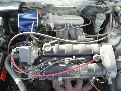 1993 Mazda MX-6 - Close-up view of a Honda engine, an aftermarket air intake and visible engine components.