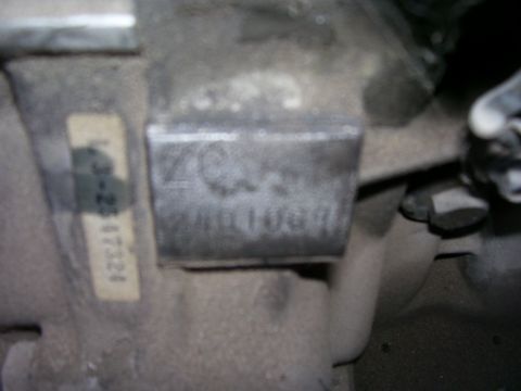 1993 Mazda MX-6 - A close-up view of a vehicle's identification plate and a label with some numbers.