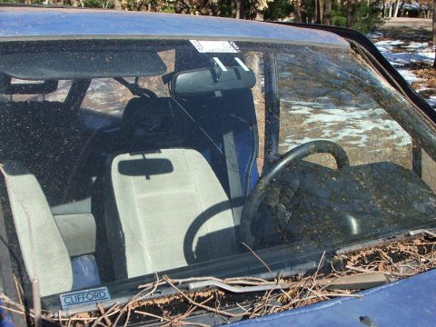 1990 Dodge Shadow - Interior view of a blue car with a cracked windshield and debris. A 'CLIFFORD' sticker is present on the dashboard.