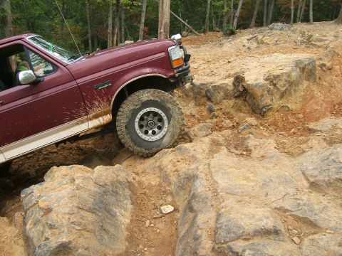 1993 Ford Bronco - Maroon Ford Bronco navigates a challenging rocky off-road course.