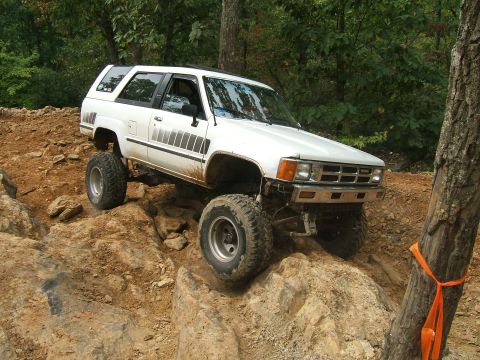 1993 Ford Bronco - This modified 4Runner is navigating a difficult rocky obstacle on an off-road trail.