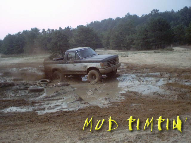Mud-splattered Ford Bronco in a muddy off-road pit with 'MUD PIMPIN' text overlay