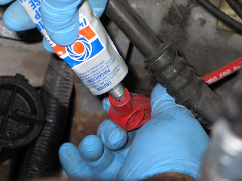 1994 Ford Bronco - Applying sealant to a spark plug boot during engine maintenance.