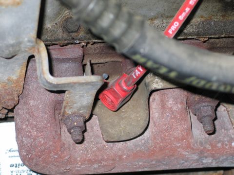 1994 Ford Bronco - Detail of an engine's exhaust manifold and spark plug wire.