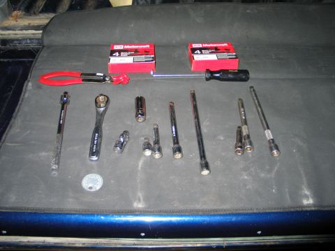 1994 Ford Bronco - Collection of automotive tools including spark plugs and various socket wrenches.