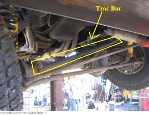 1974 Ford F-100 - Close-up view of the suspension and steering components underneath a vehicle, with yellow markings highlighting specific parts.