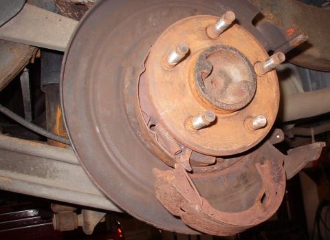 1999 Ford Crown Victoria - After removing all other parts, pry the bottom of the shoe nearest the caliper toward the caliper area, then outboard to clear the lower lu…