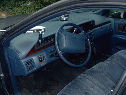 1991 Ford Crown Victoria - The interior of a 1991 Chevrolet Caprice features blue velour seats and a blue dashboard with wood trim accents.