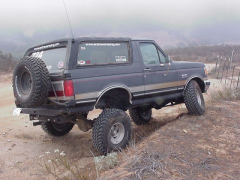 1988 Ford Bronco - This Ford Bronco is shown off-road, with large tires and a spare mounted on the rear.
