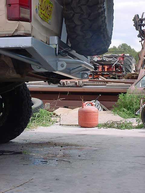 1990 Ford Bronco - Spare tire mounted on the rear of a truck, with a gas can and other vehicles visible.