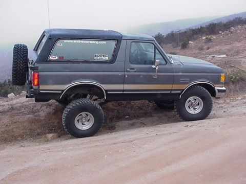 1988 Ford Bronco - This lifted Ford Bronco is equipped with off-road tires and a spare tire mounted on the rear.