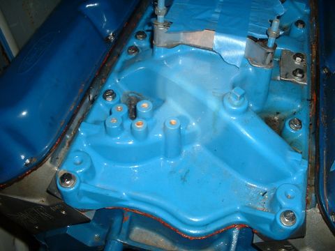 1985 Ford Bronco - Close-up of a blue engine manifold with visible bolts and brackets, suggesting an engine part rather than a complete vehicle.