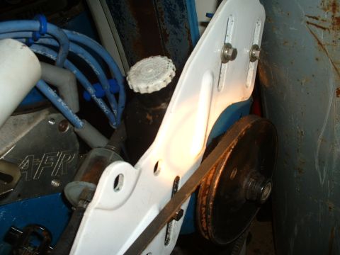 1985 Ford Bronco - Close-up view of engine components including spark plug wires, a fluid reservoir, and a belt-driven pulley system.