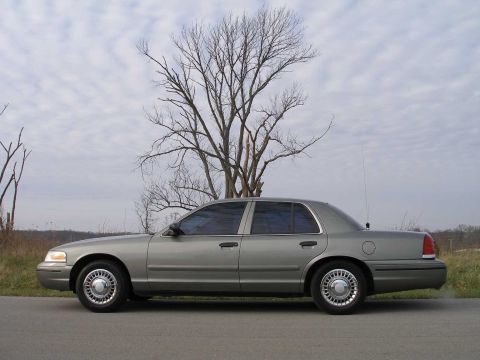 2001 Ford Crown Victoria - A silver 2001 Ford Crown Victoria is shown from the side, parked outdoors under a cloudy sky.
