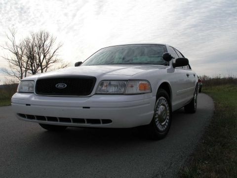 2001 Ford Crown Victoria - Front 3/4 view of a white 2001 Ford Crown Victoria sedan on a cloudy day.