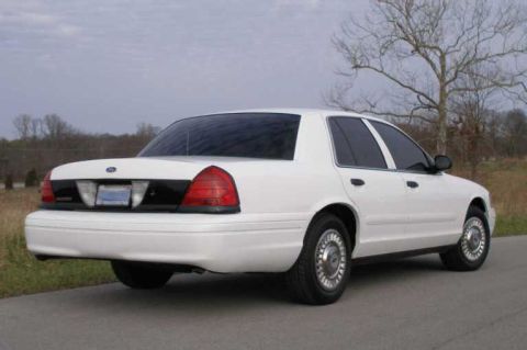 2001 Ford Crown Victoria - Rear view of a white 2001 Ford Crown Victoria parked on a road.