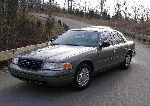 2001 Ford Crown Victoria - A 2001 Ford Crown Victoria is parked on a road, viewed from the front three-quarter angle.