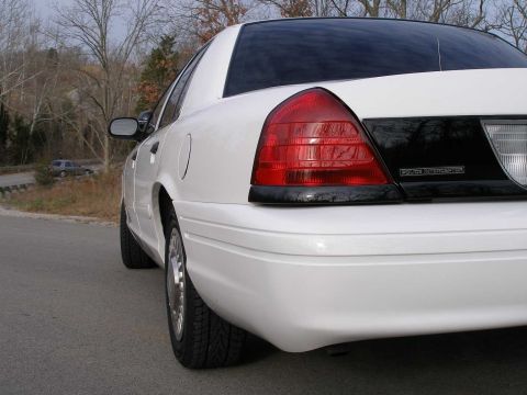 2001 Ford Crown Victoria - Rear view of a white 2001 Ford Crown Victoria, showing its distinctive taillights and body style.