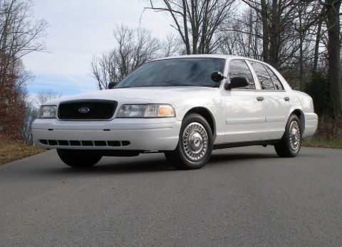 2001 Ford Crown Victoria - Front 3/4 view of a white 2001 Ford Crown Victoria sedan on a paved road.